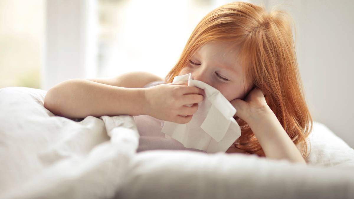 Alergia infantil &ndash; menina com pele sens&iacute;vel co&ccedil;ando o bra&ccedil;o