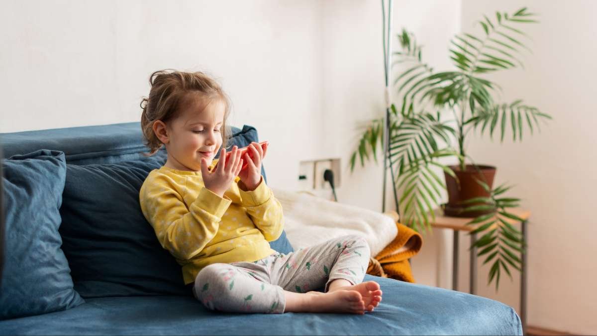 Crian&ccedil;a com o primeiro celular nas m&atilde;os, sob supervis&atilde;o