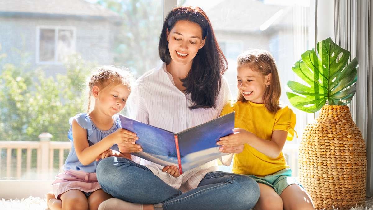 Mãe e filhas lendo livro – hábito de leitura em família